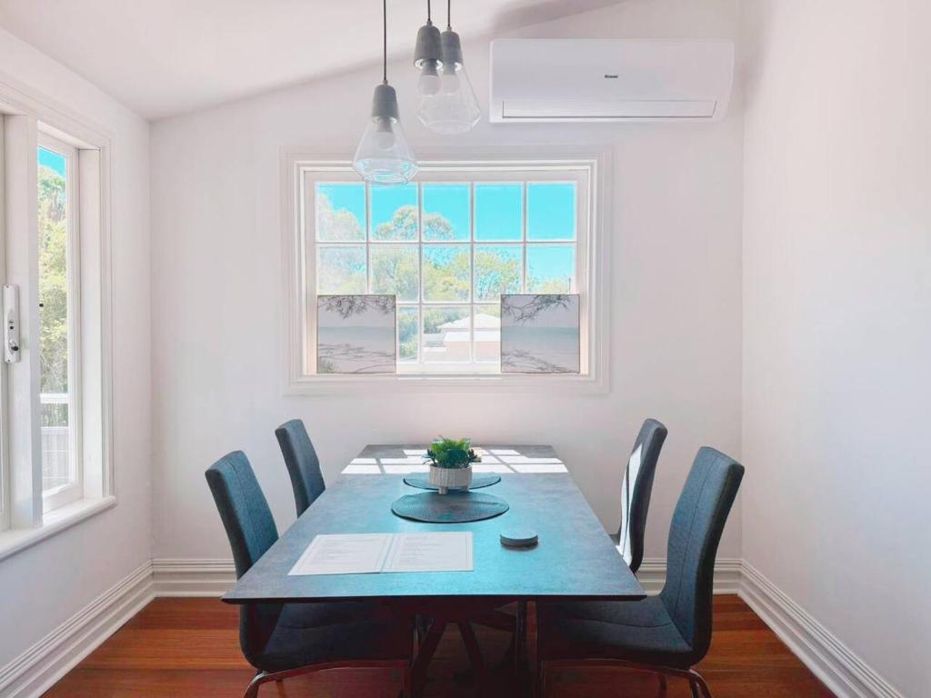 a dining room with a table and chairs and a window at Full house - Heritage Charm Meets Modern Ease in Midland Junction
