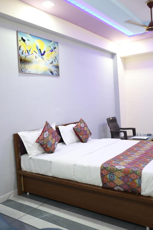 a bedroom with a bed and a painting on the wall at Hotel Dipak in Himatnagar