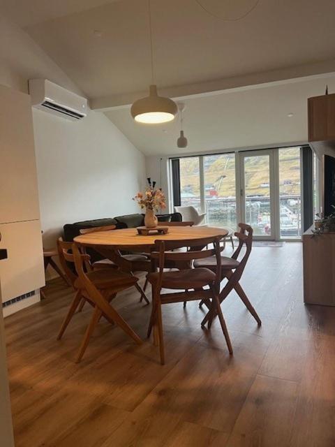 a dining room with a wooden table and chairs at The Red Boat House in Vestmanna
