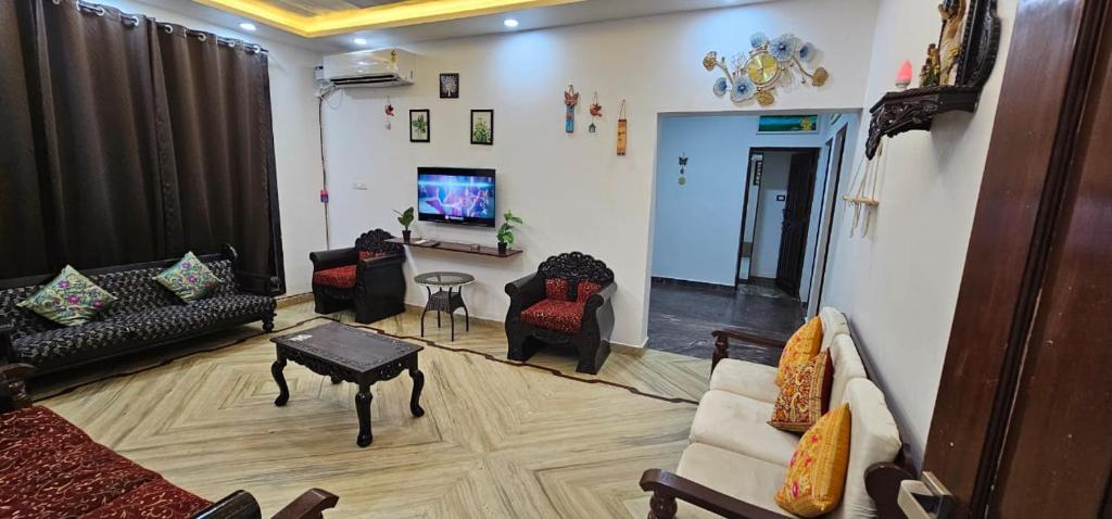 a living room with couches and a flat screen tv at Hotel blue ocean baga beach away in Arpora