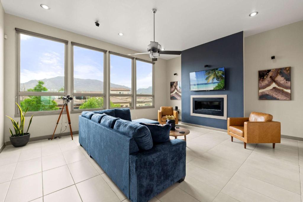 a living room with a blue couch and some windows at Mountain View Pool House Villa in El Paso