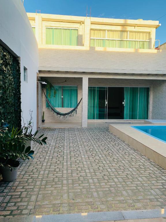 a house with a swimming pool in front of it at Jesaluguel-de-casa in Cabo Frio