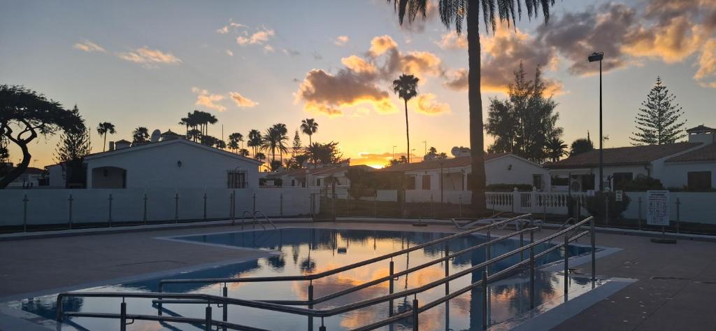 a sunset over a swimming pool in a parking lot at Santa Barbara by Placida Mar in Playa del Ingles