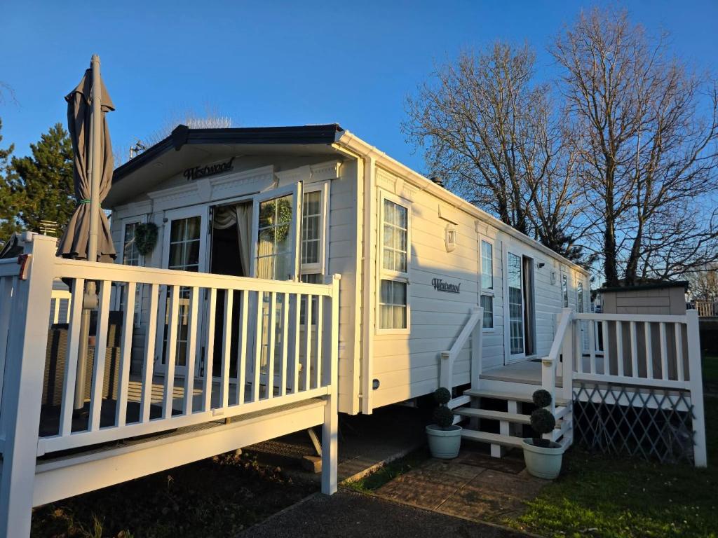 a yellow tiny house with a white railing at Westwood Hide Away in Allhallows