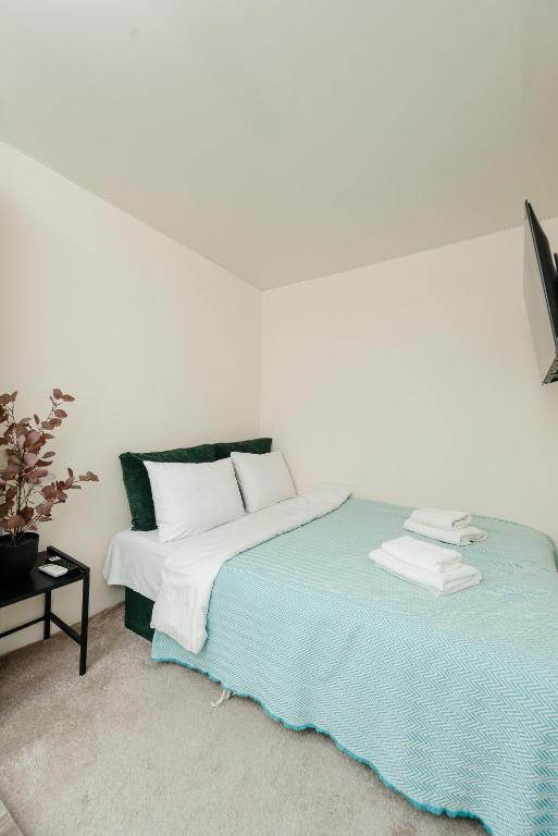 a white bedroom with a bed and a white wall at Studio Room Central in Chişinău