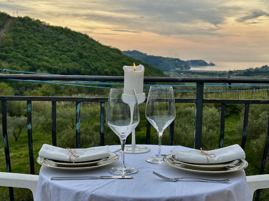a table with a candle and two wine glasses at Saleto Apartma in Jagodje