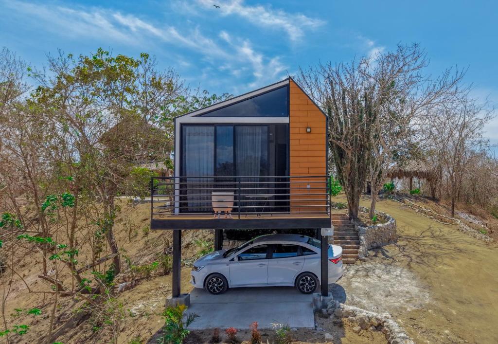 a tiny house with a car parked in front of it at Cabañas Raíces del Cielo in Estorpio