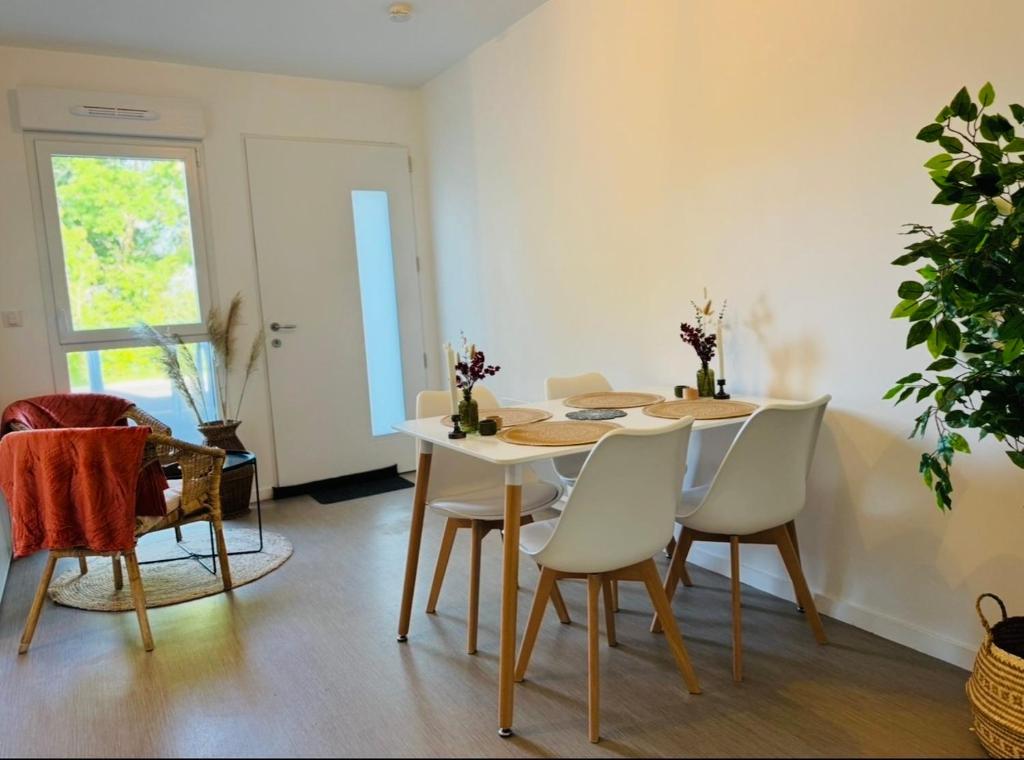 a dining room with a white table and chairs at Studio confortable central in La Roche-sur-Yon