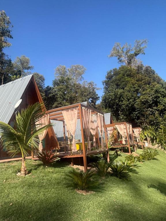 a house with glass doors and a grass yard at Pousada Dona Carmita in Brumadinho