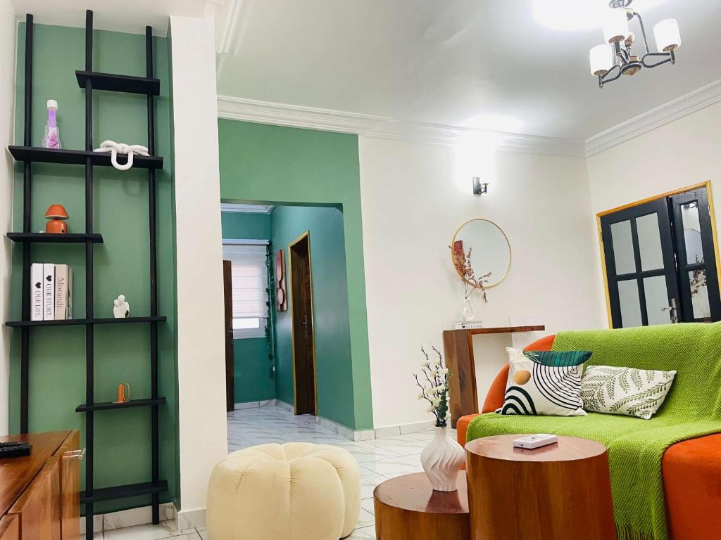 a living room with a green couch and a table at Rieti Yamehome in Yaoundé