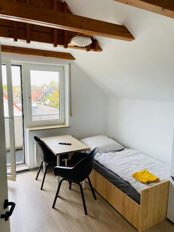 a bedroom with a bed and a desk and a window at Monteur Apartment Lingen Zentrum in Lingen