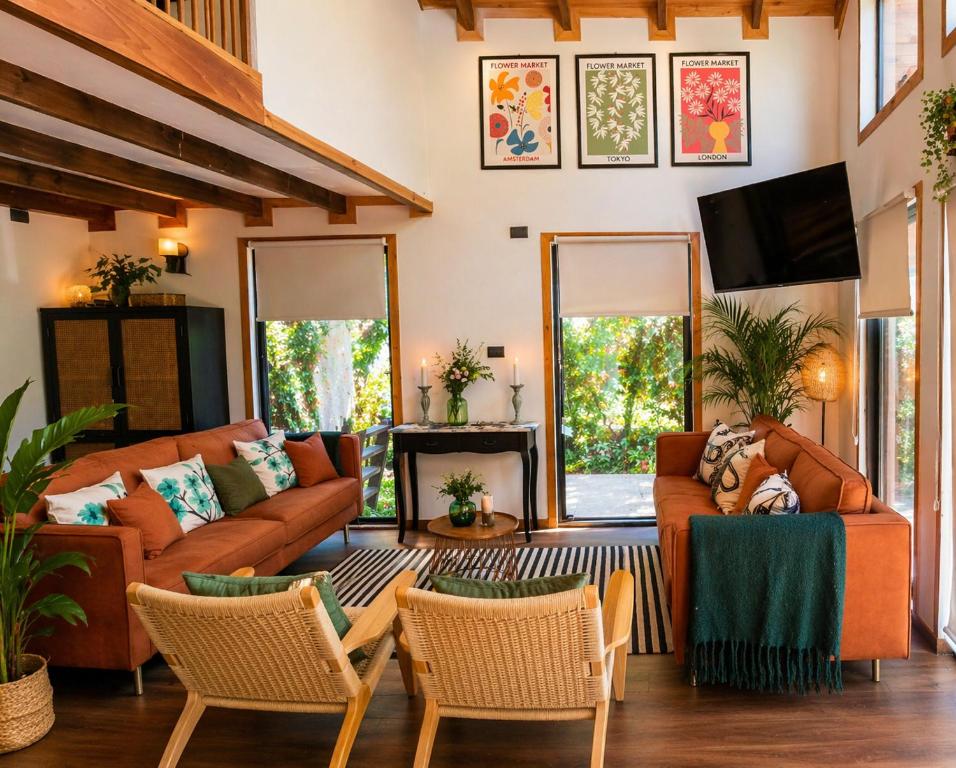a living room with two couches and a tv at Casa Hortencia in Coñaripe