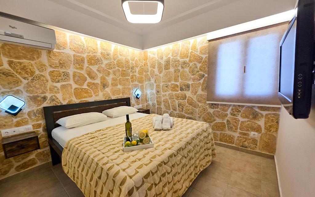a bedroom with a bed with a table with wine bottles at Casa Bella a Skala 1 in Skala