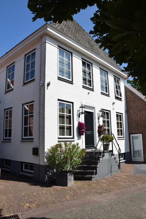a white house with stairs and flowers on it at De Witte Gans in Ootmarsum