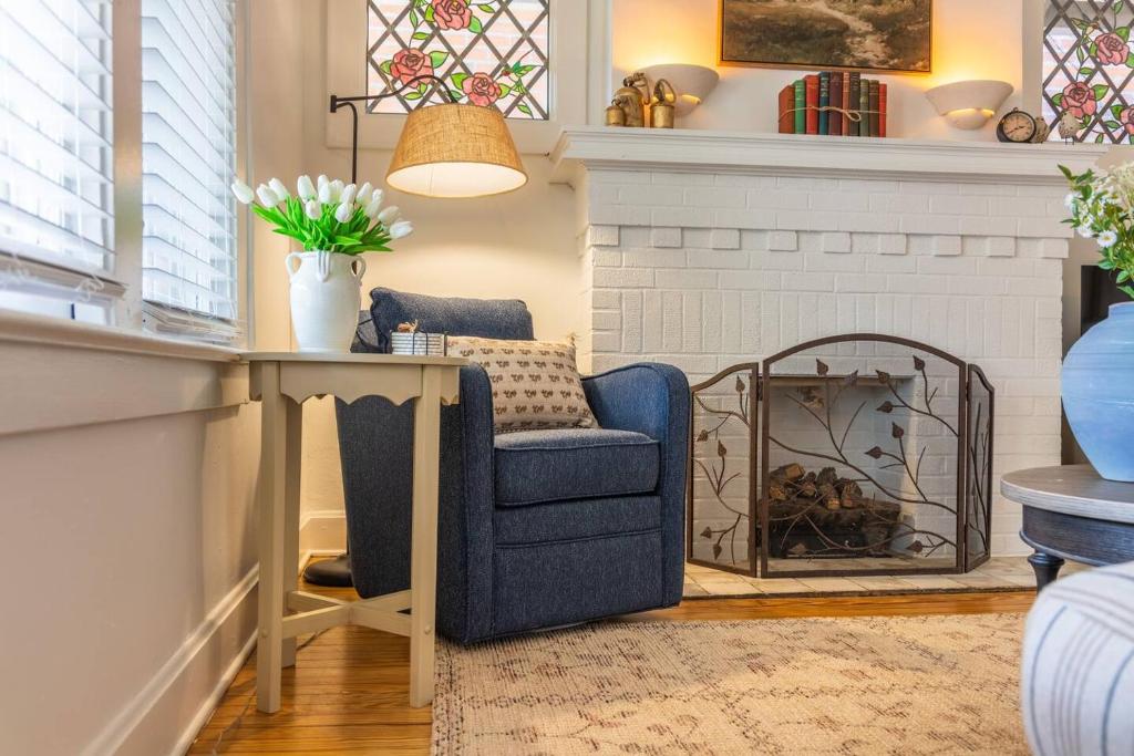 a living room with a blue chair and a fireplace at Walkable Designer Cottage In GV in Columbus
