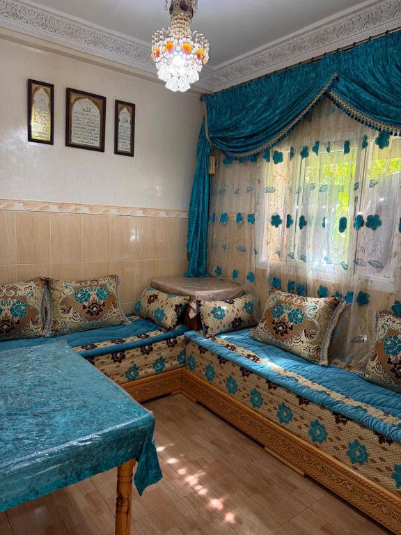 a living room with two beds and a chandelier at Apartamento con wifi in Nador