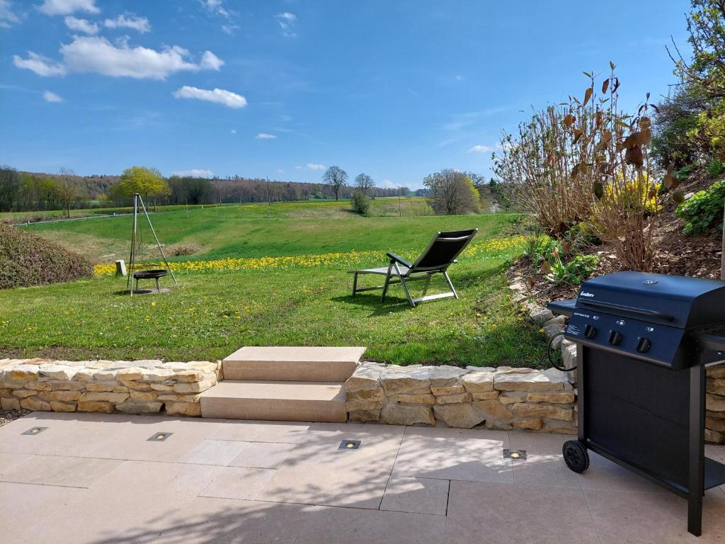 a grill and a chair in a yard at Apartment in Stetten bei Mindelheim in Stetten