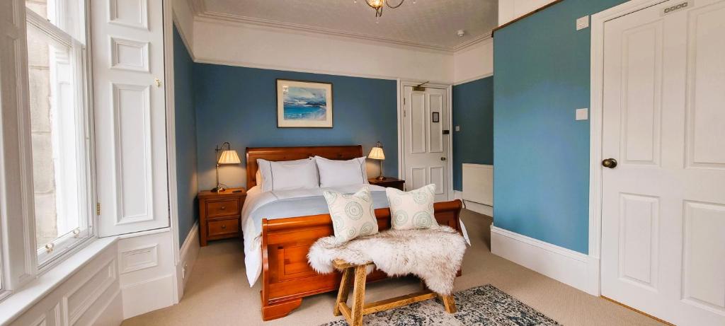 a bedroom with a bed and a blue wall at Craigbuie Guesthouse in Killin