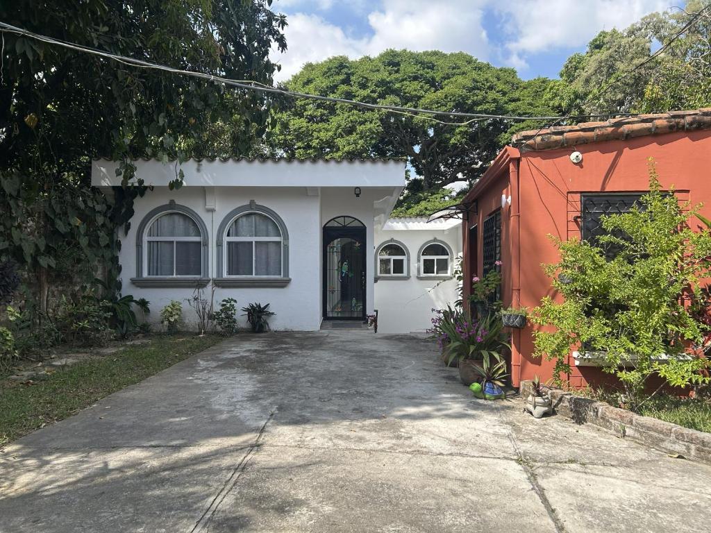 a white and orange house with a driveway at Quinta Pompella in San Salvador