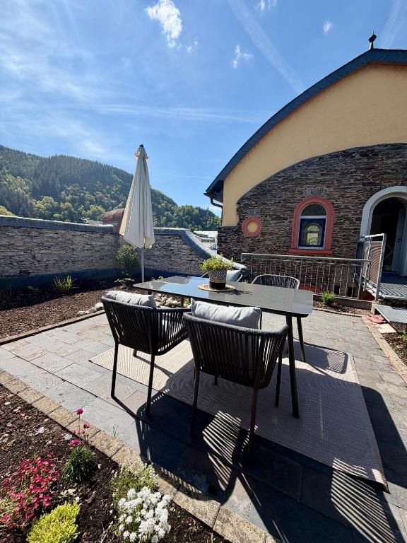 a table and chairs and an umbrella on a patio at Urlaubsschmiede Mosel in Traben-Trarbach