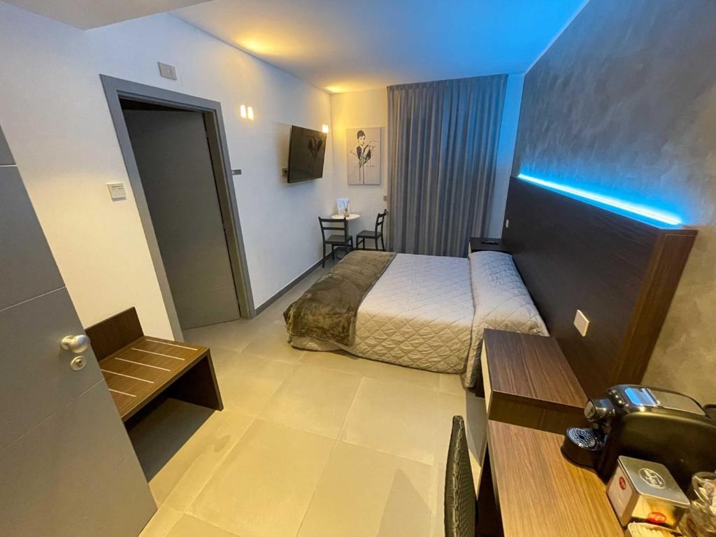 a hotel room with a bed and a blue light at BRIGANTE SUITES in Misano Adriatico
