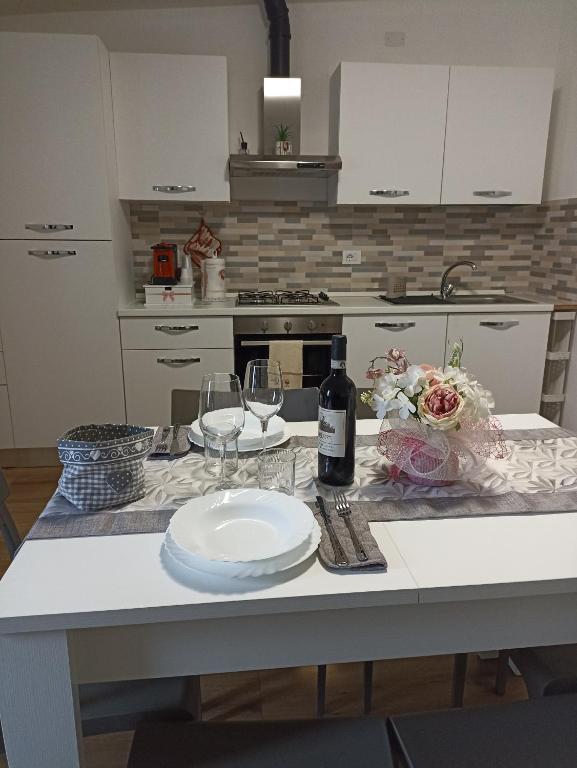 a kitchen with a table with a plate and wine glasses at Rifugio nel Borgo in Grosseto