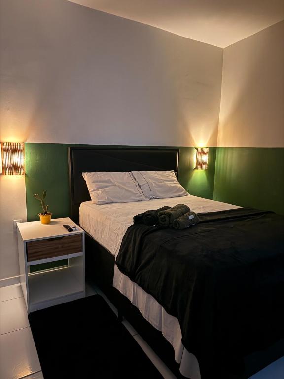 a bedroom with a bed with a green headboard at Loft Marinês in Campina Grande