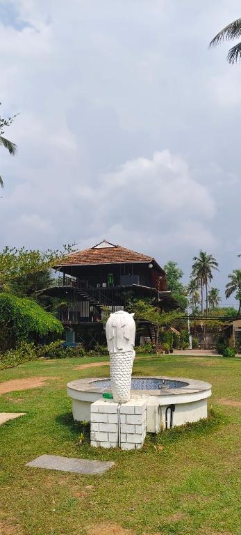 a fountain in a park with a building in the background at Mangro villa in Mayyanād