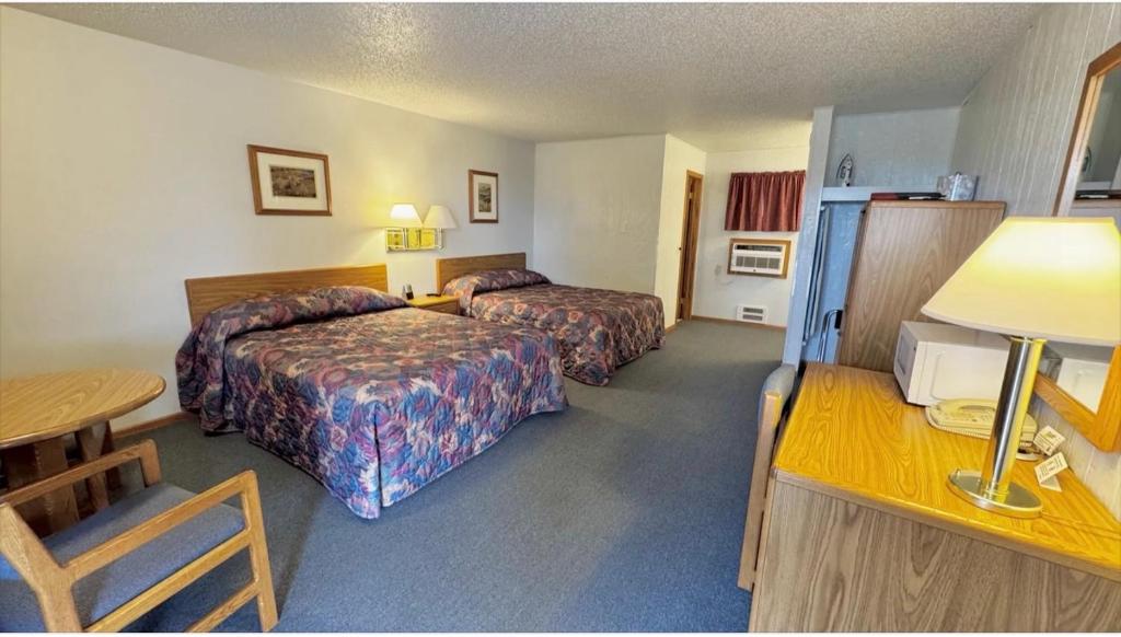 a hotel room with two beds and a table at North Winds Lodge LLC in Bowman
