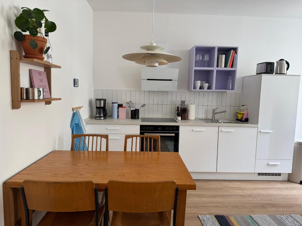 a kitchen with white cabinets and a wooden table at Zum Alten Pasewalker Kaufmann Beletage in Pasewalk