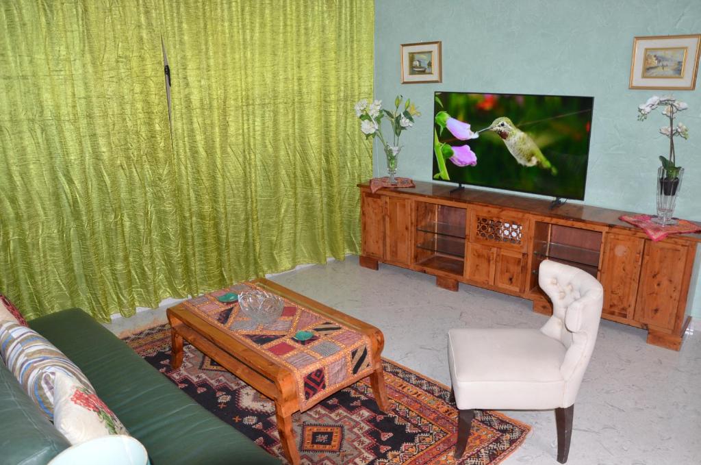 a living room with a couch and a tv at Residence 33 vèrte in Guelmim