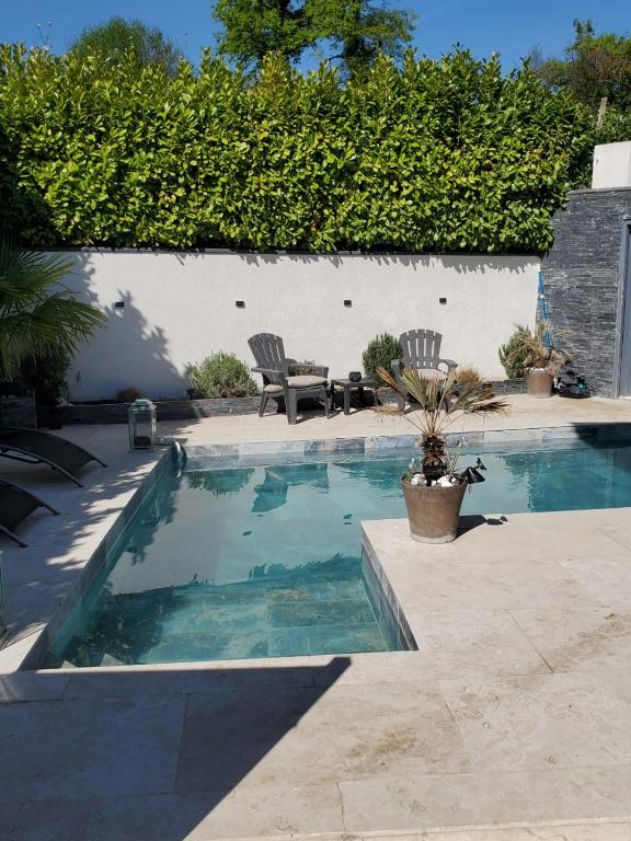 a swimming pool with two chairs and a bench next to it at annecy poisy Studio a 9 minutes du lac Annecy in Poisy