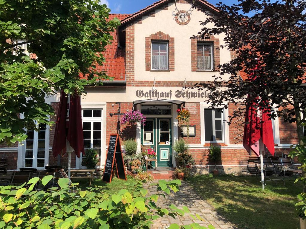 a building with a sign that reads original epiculture at Gasthaus Schwielochsee in Friedland