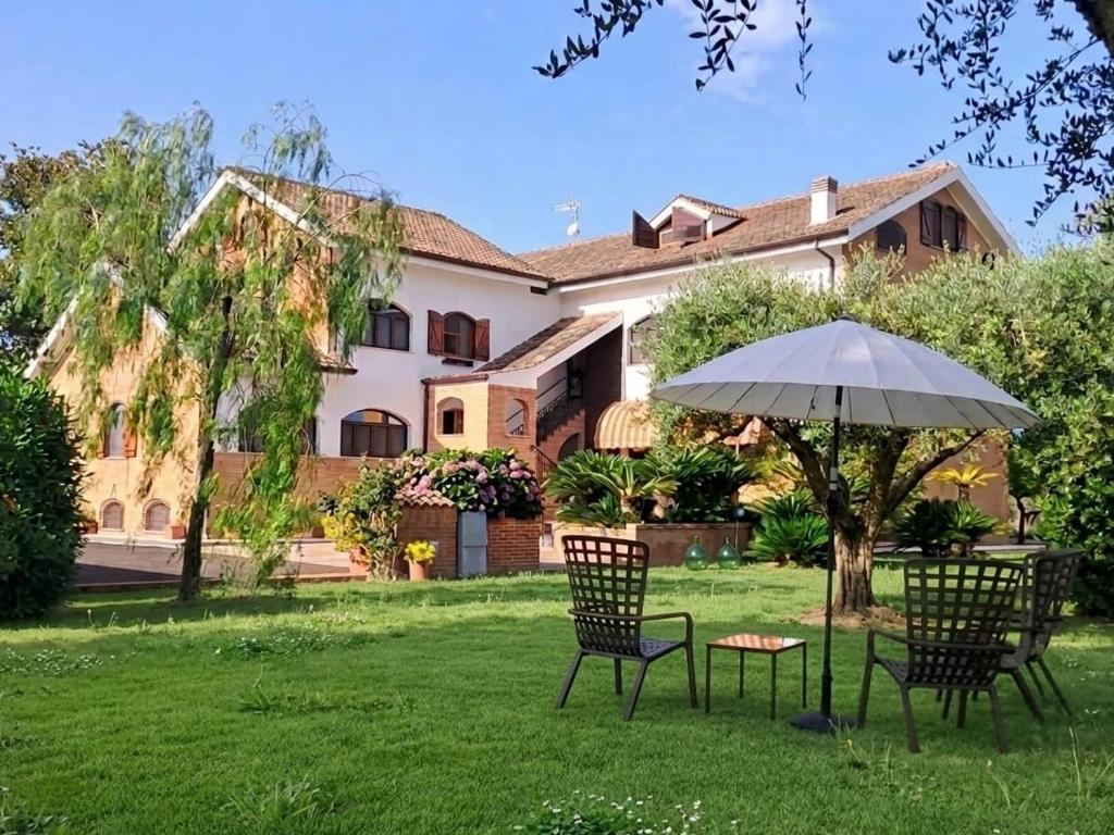 two chairs and an umbrella in front of a house at Appartamenti La Cicadea in Terracina
