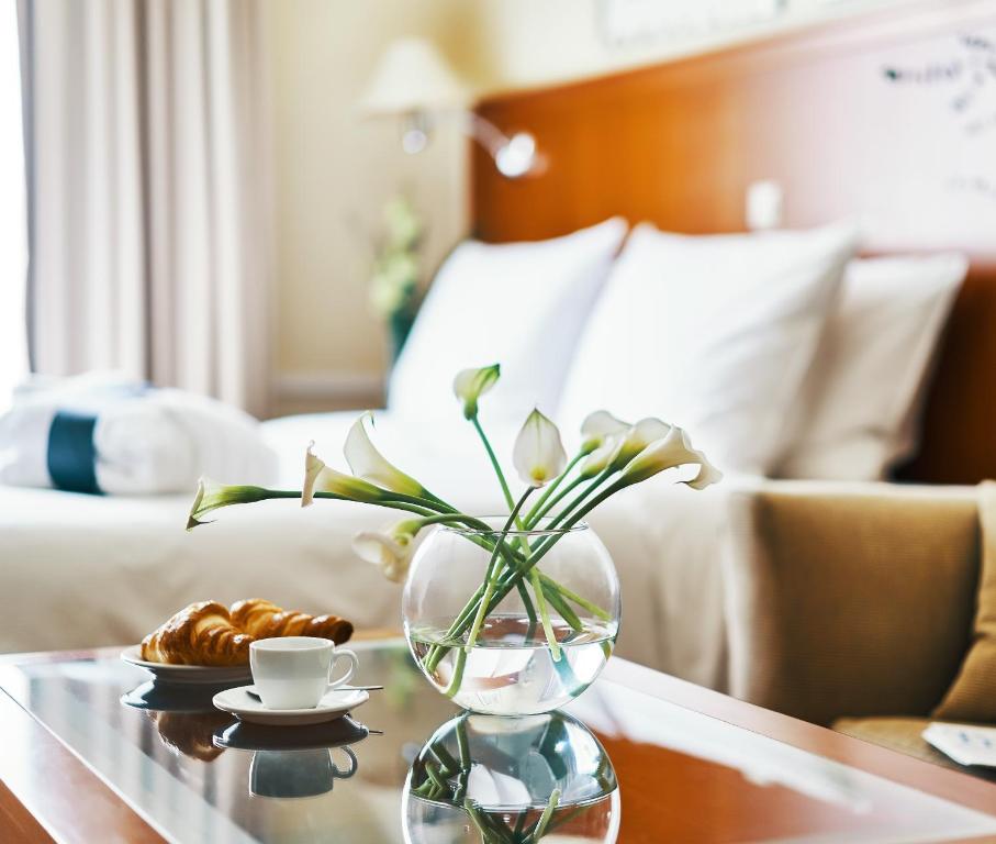 a table with a vase of flowers on a table at Radisson Blu Ridzene Hotel, Riga in Riga