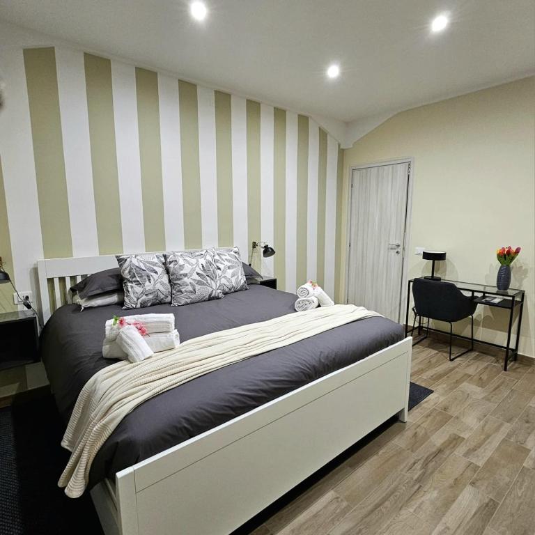 a bedroom with a large bed with striped walls at Maison dei Mori in Messina