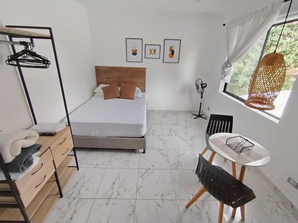 a bedroom with a bed and a table and a chair at Casa Palma Poblado in Medellín