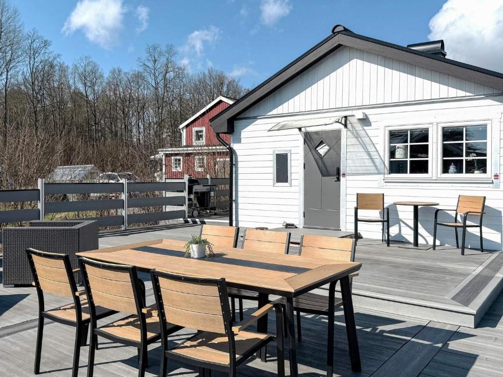 a wooden table and chairs on a deck with a building at 4 star holiday home in SÖLVESBORG in Sölvesborg