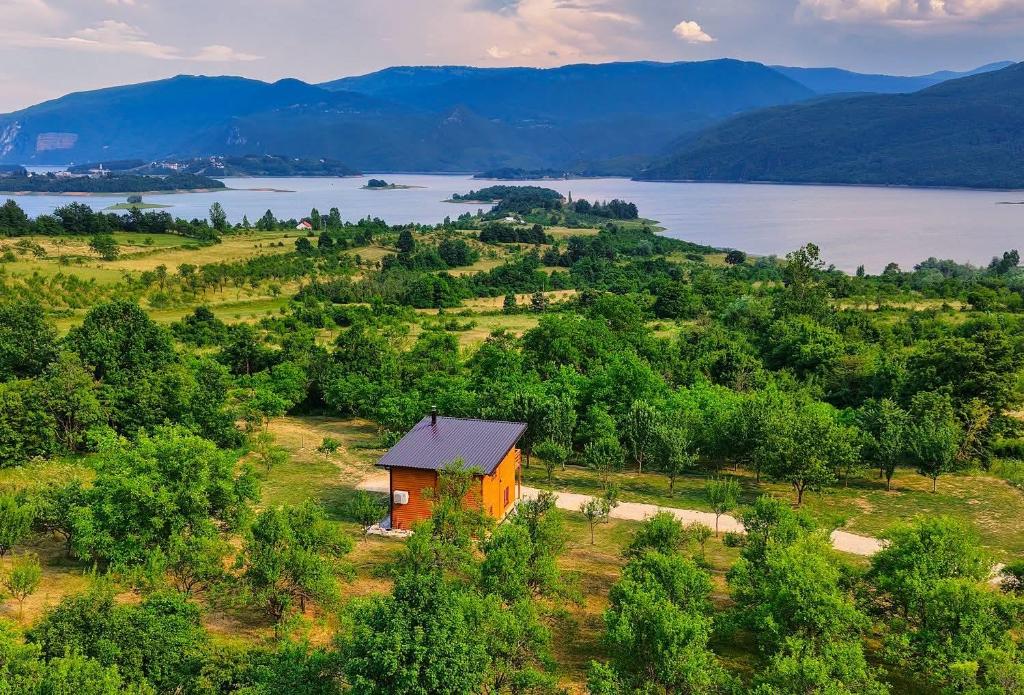 a small house on a hill next to a lake at Vikendica Diva in Varvara