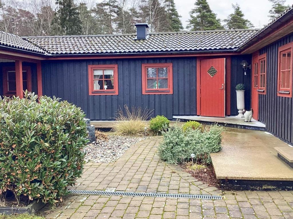 a blue house with a cat sitting outside of it at 4 star holiday home in ELDSBERGA in Eldsberga