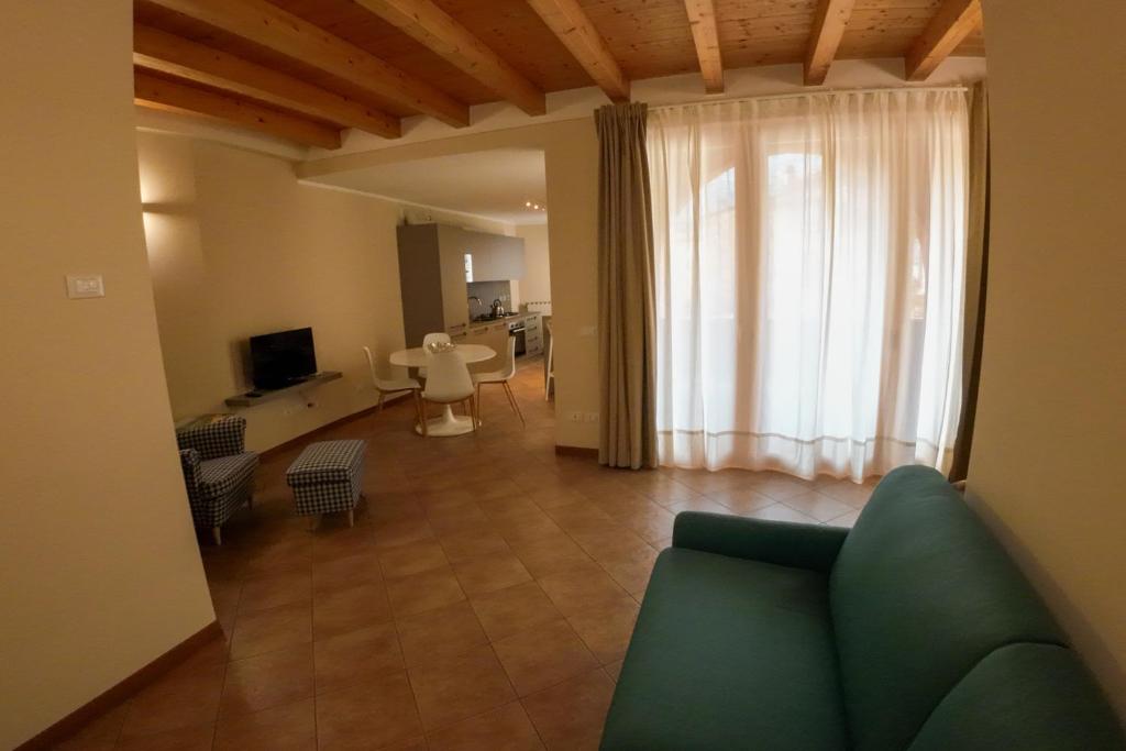 a living room with a blue couch and a window at Casa Vacanze al Lago P1 in Monasterolo del Castello