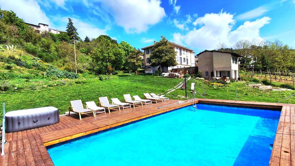 a swimming pool with lounge chairs and a house at Residenza Rosmarino CASA GUARNONE in Mornico Losana