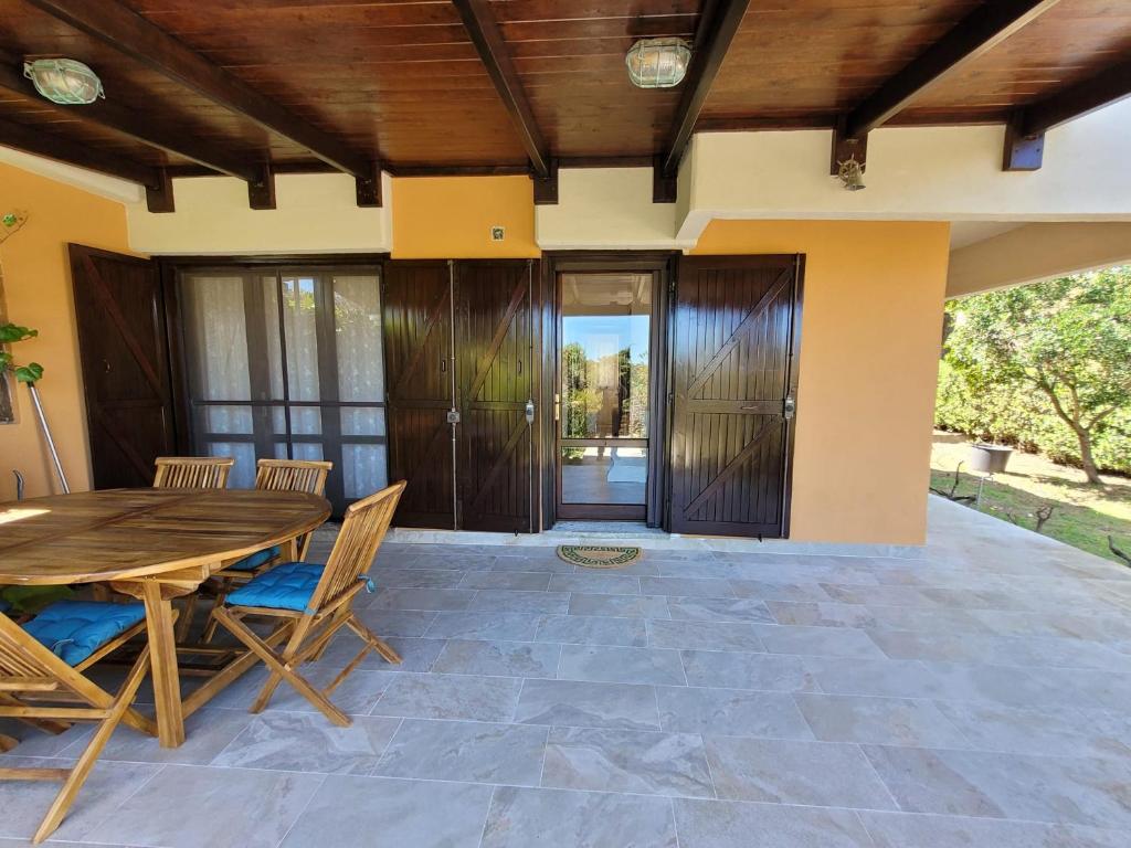a patio with a wooden table and chairs at Villa il Gabbiano Stintino in Stintino