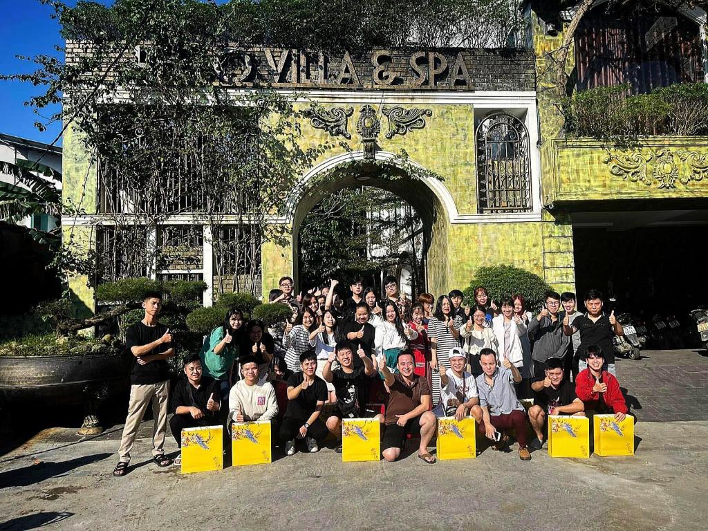 a group of people posing for a picture in front of a building at HELLO VILLA & SPA in Hue