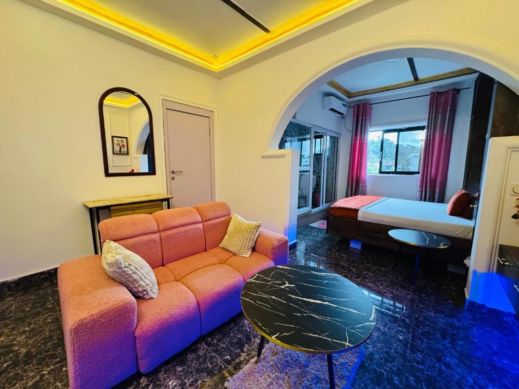 a living room with a couch and a bed at La Castrol Hotel Apartments in Limbe