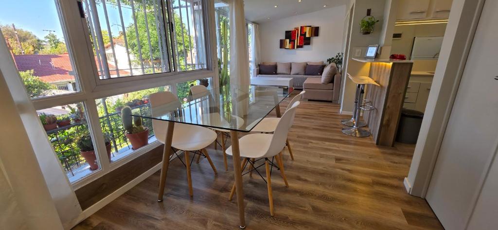 a dining room and living room with a glass table and chairs at Departamento PH en Martinez in Martínez