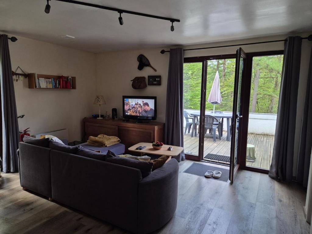 a living room with a couch and a sliding glass door at Appartement confortable Dog friendly in Membre
