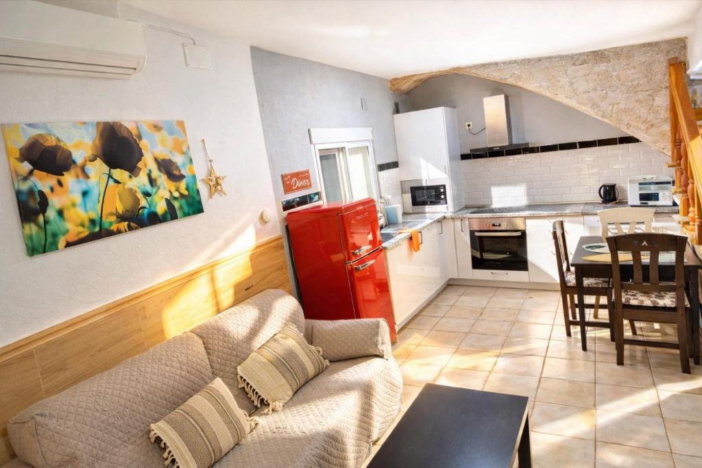 a living room with a couch and a kitchen at CASA ADELA - Playa 2 min - Aire Acondicionado - WIFI - Parking cercano in Barbate