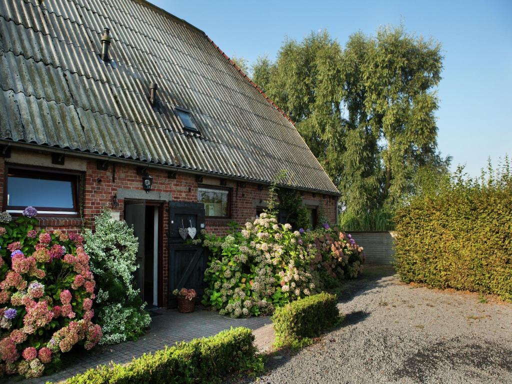 a brick house with flowers in front of it at Farmhouse appartment in Eede in Eede