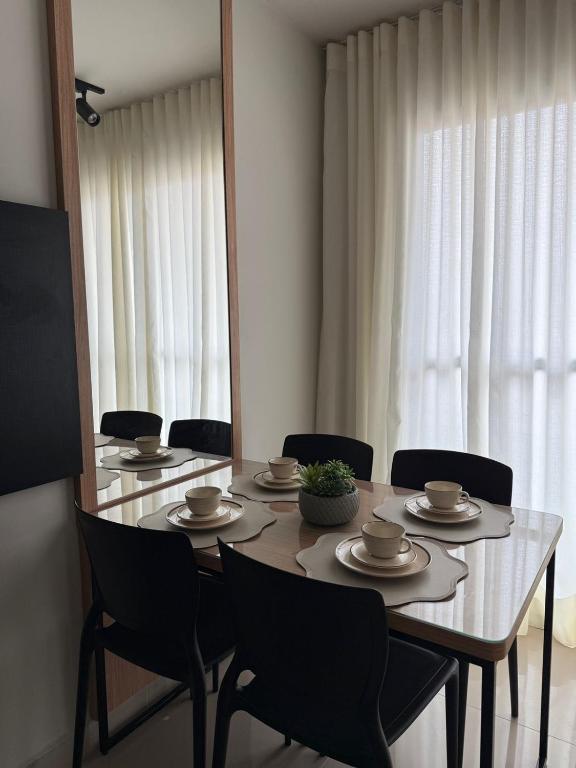 a dining room table with chairs and a mirror at 098house havana in São Luís